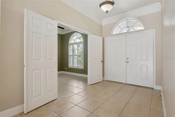 an empty room with windows mirror and fan
