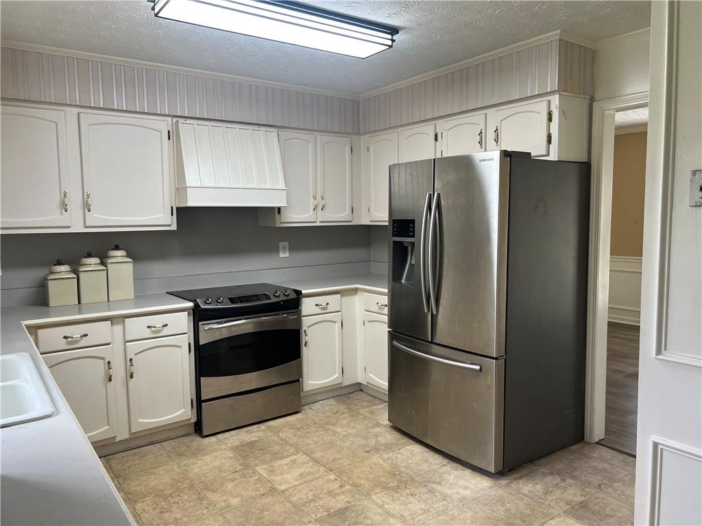 1725 Spindle Top Court Southwest Lilburn, GA 30047 - Photo 11 of 30 a kitchen with stainless steel appliances granite countertop a refrigerator a stove a sink and cabinets
