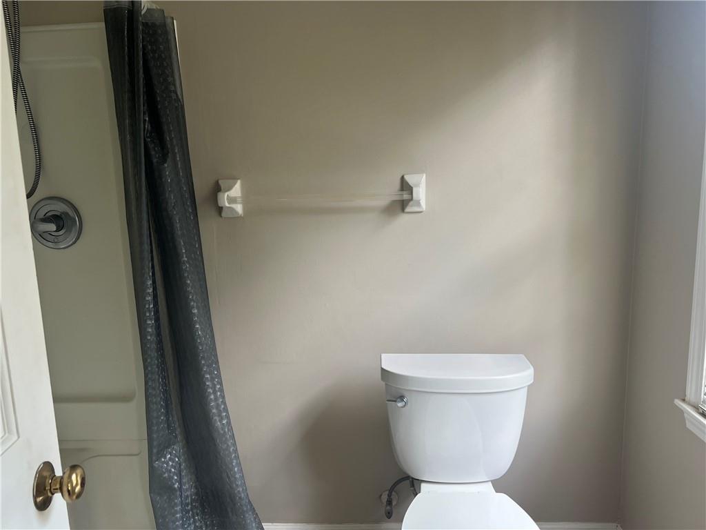 1725 Spindle Top Court Southwest Lilburn, GA 30047 - Photo 15 of 30 a white toilet sitting next to a shower