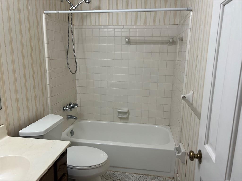 1725 Spindle Top Court Southwest Lilburn, GA 30047 - Photo 19 of 30 a bathroom with a shower a toilet and a sink