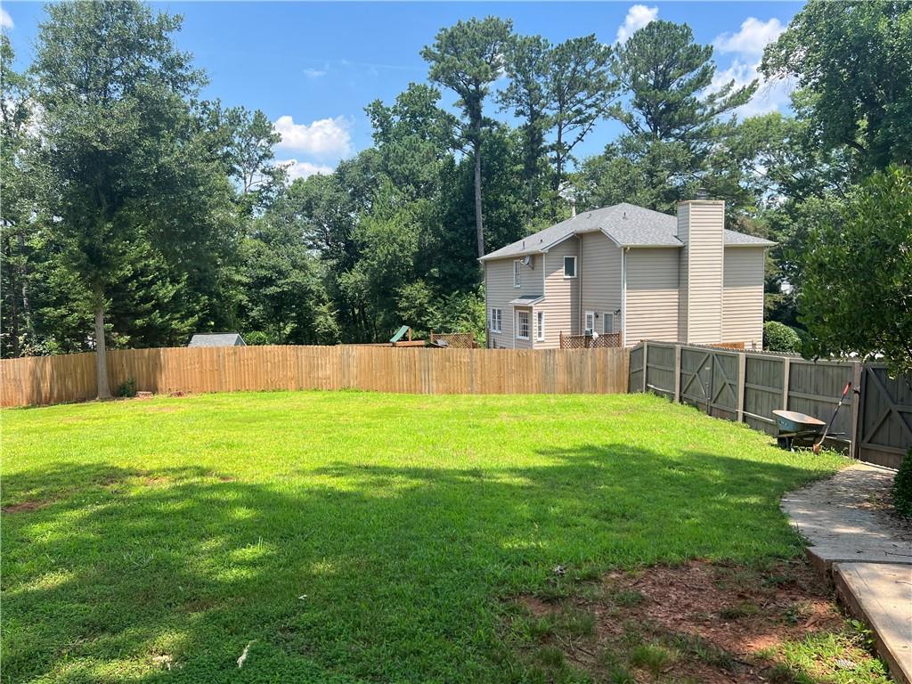 1725 Spindle Top Court Southwest Lilburn, GA 30047 - Photo 27 of 30 a view of a backyard with a garden and trees