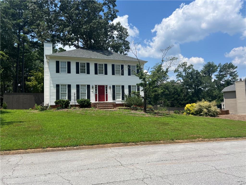 1725 Spindle Top Court Southwest Lilburn, GA 30047 - Photo 29 of 30 a front view of a house with a garden and yard