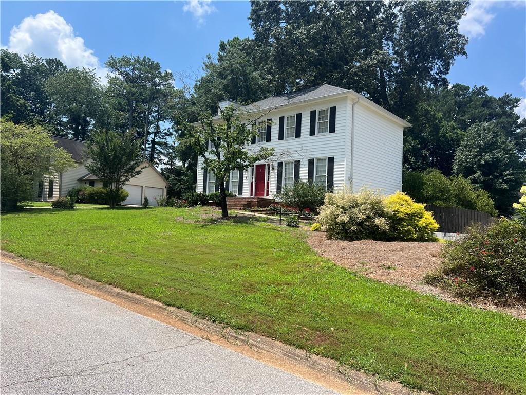 1725 Spindle Top Court Southwest Lilburn, GA 30047 - Photo 30 of 30 a front view of a house with a yard and trees