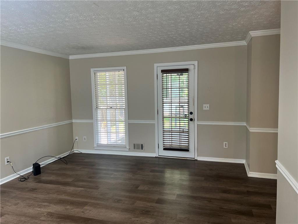 1725 Spindle Top Court Southwest Lilburn, GA 30047 - Photo 4 of 30 an empty room with wooden floor and windows