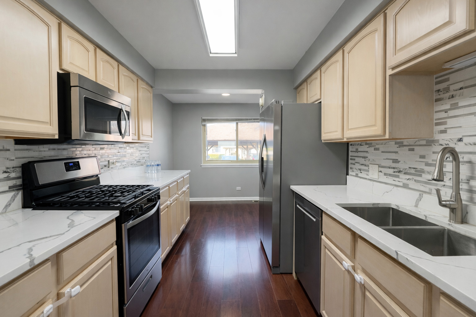1527 Mohawk Trail Wheeling, IL 60090 - Photo 4 of 21 a kitchen with stainless steel appliances granite countertop a stove a sink and a microwave