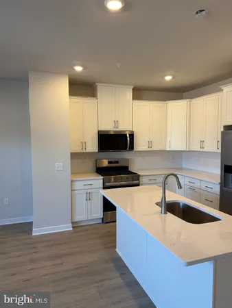a kitchen with granite countertop a sink a counter top space and cabinets