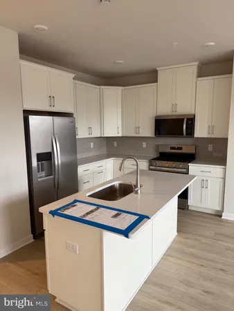 a kitchen that has a lot of cabinets and stainless steel appliances