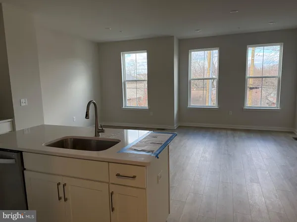 a kitchen with a sink and wooden floor