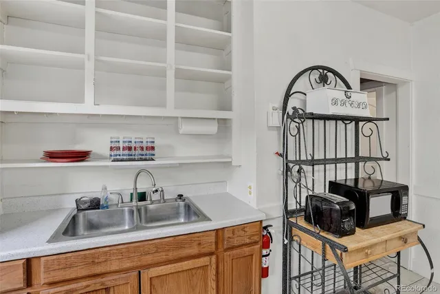 a kitchen with a sink a stove and a wooden floor