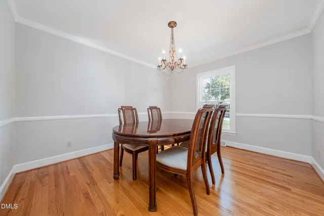 a dining room with stainless steel appliances a table and chairs with the wooden floor