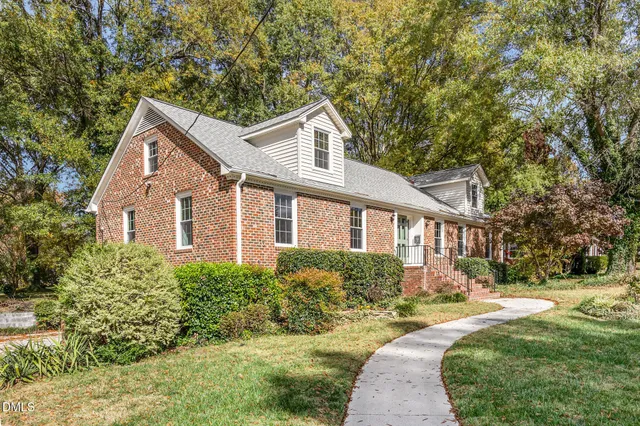 a front view of a house with a yard and trees