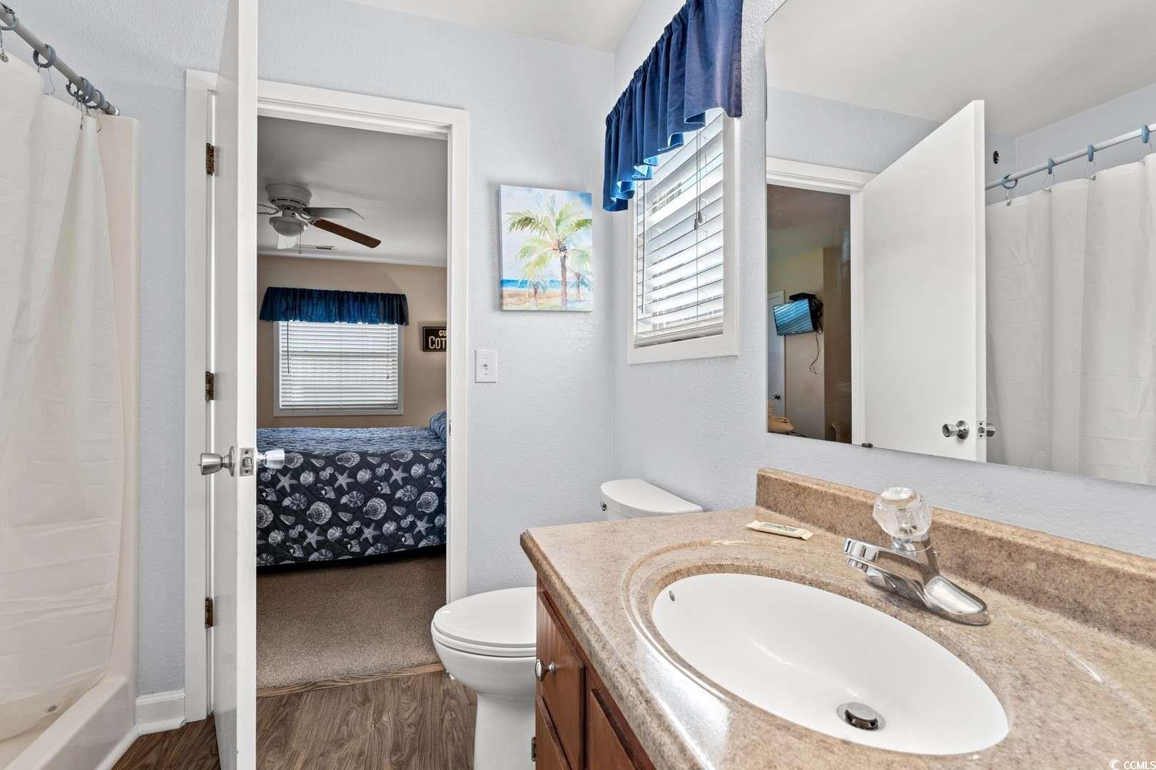 9500 Queens Court Myrtle Beach, SC 29572 - Photo 17 of 33 Bathroom with ensuite bathroom, a wealth of natural light, a ceiling fan, and vanity