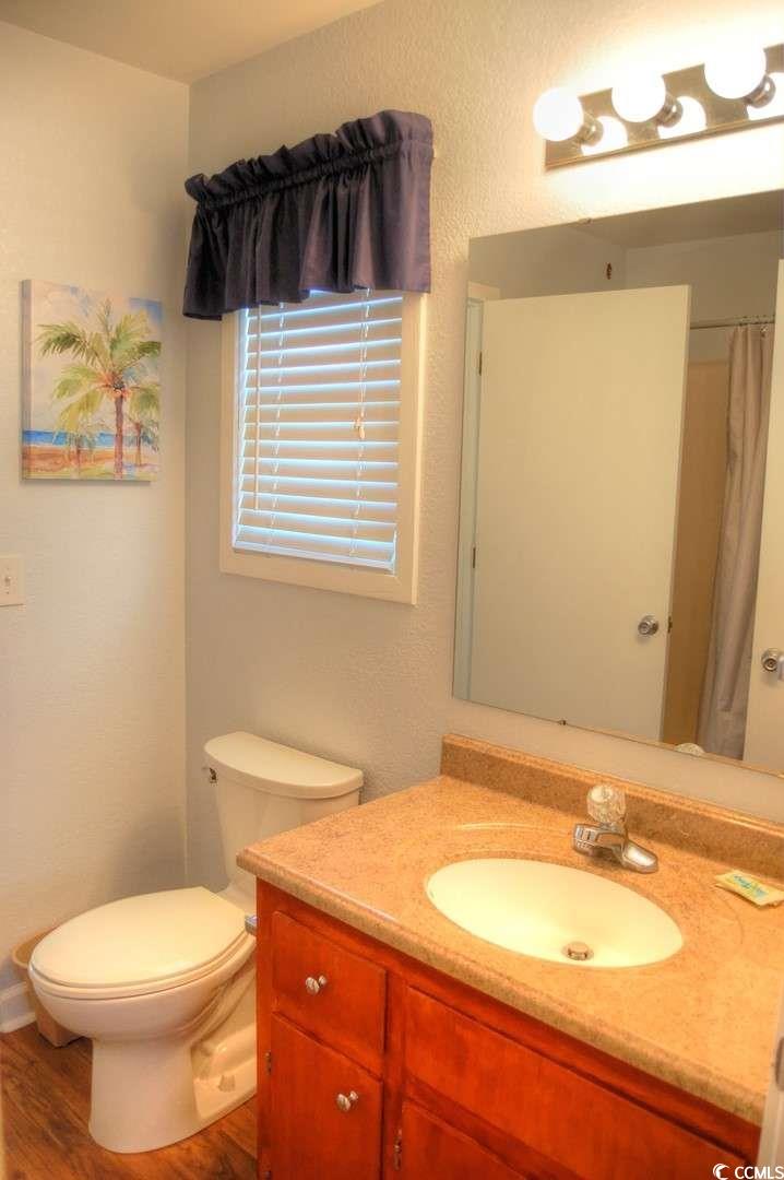 9500 Queens Court Myrtle Beach, SC 29572 - Photo 19 of 33 Full bath with toilet, vanity, and wood finished floors