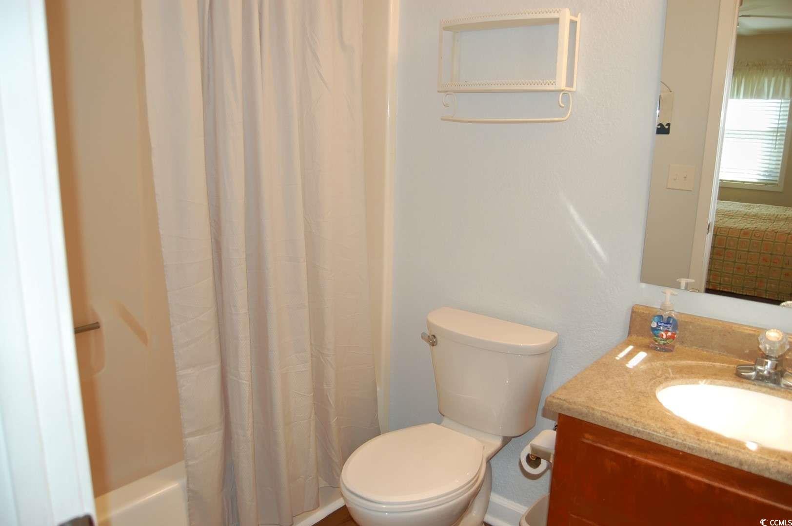 9500 Queens Court Myrtle Beach, SC 29572 - Photo 20 of 33 Bathroom with toilet, vanity, and shower / bath combination with curtain