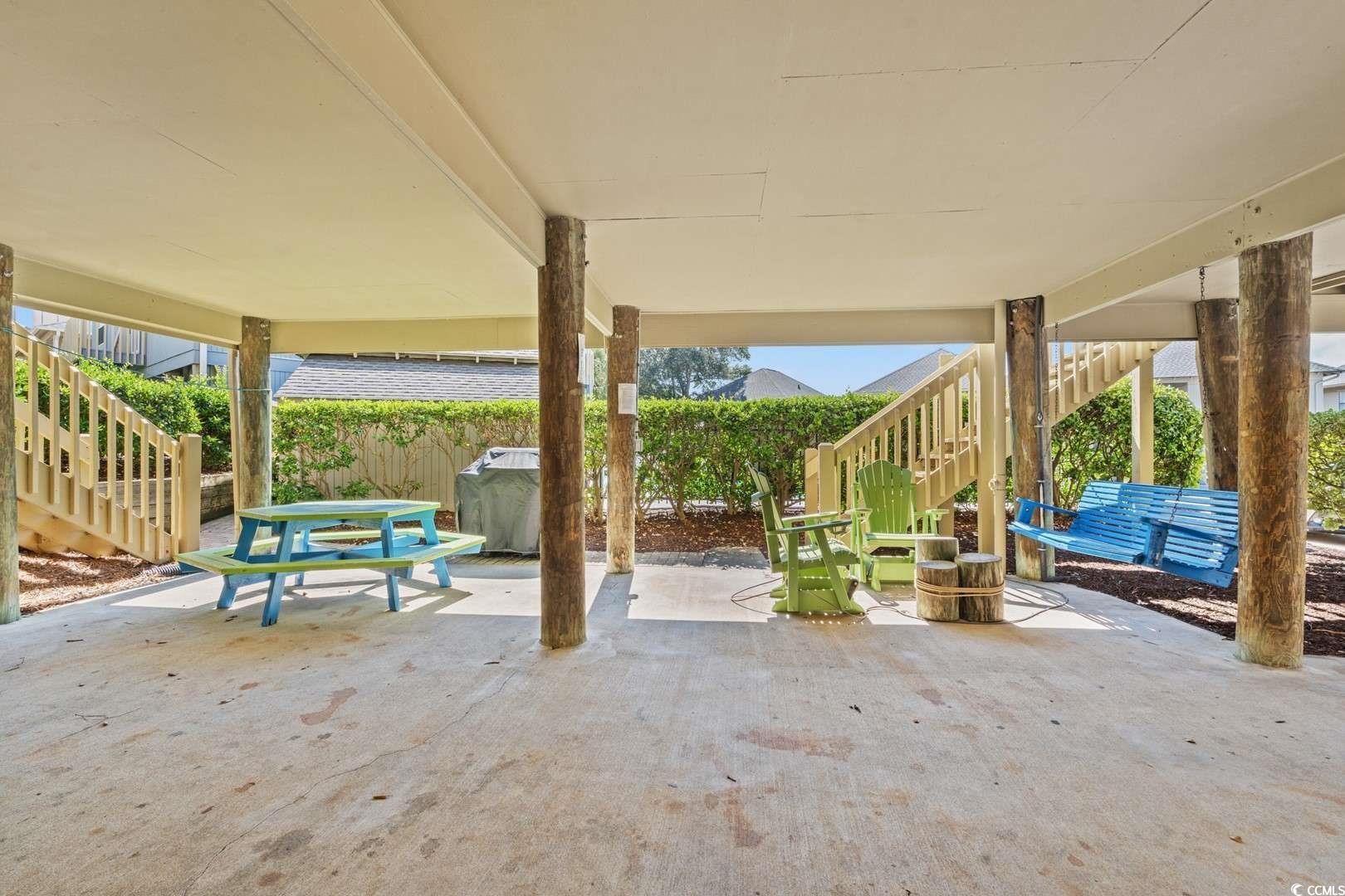 9500 Queens Court Myrtle Beach, SC 29572 - Photo 23 of 33 View of patio featuring fence, outdoor dining area, and stairway