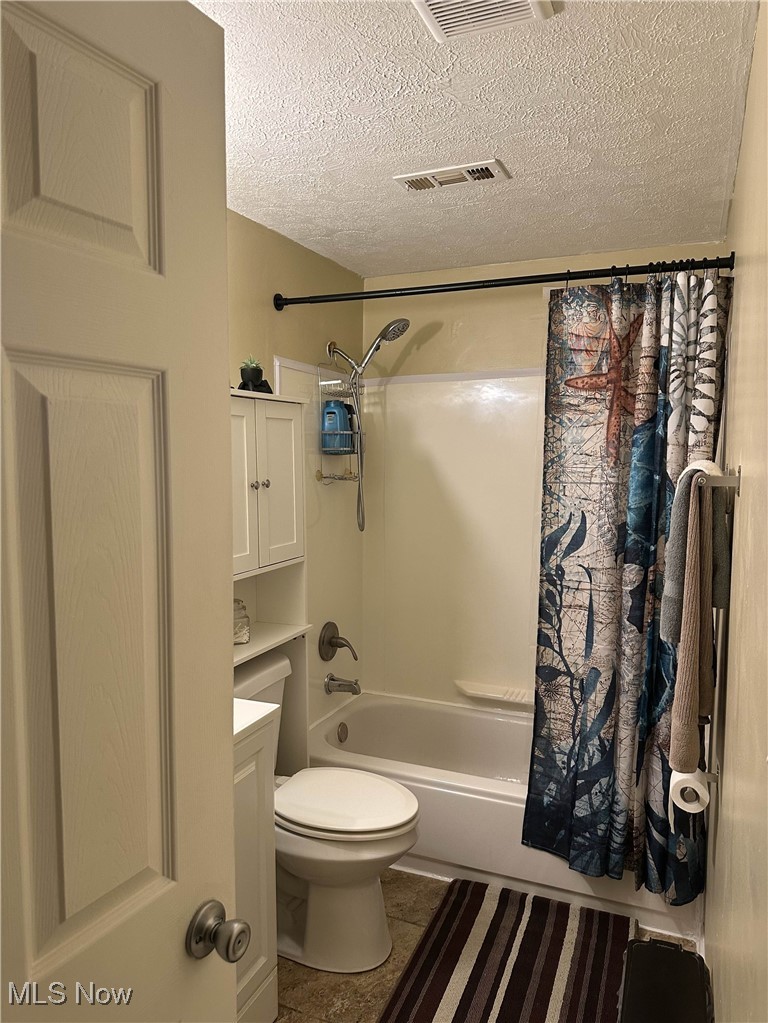 558 Frost Road Streetsboro, OH 44241 - Photo 12 of 32 Bathroom with shower / bath combo with shower curtain, a textured ceiling, vanity, and tile patterned floors