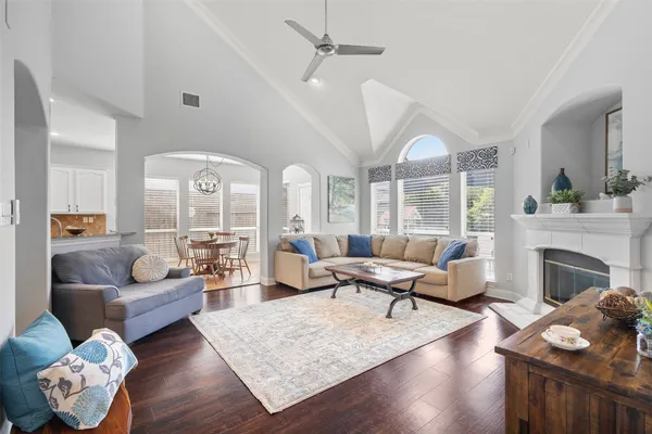 a spacious bedroom with a bed a couch and a chandelier fan