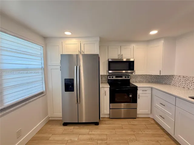 a kitchen with granite countertop a refrigerator and a stove