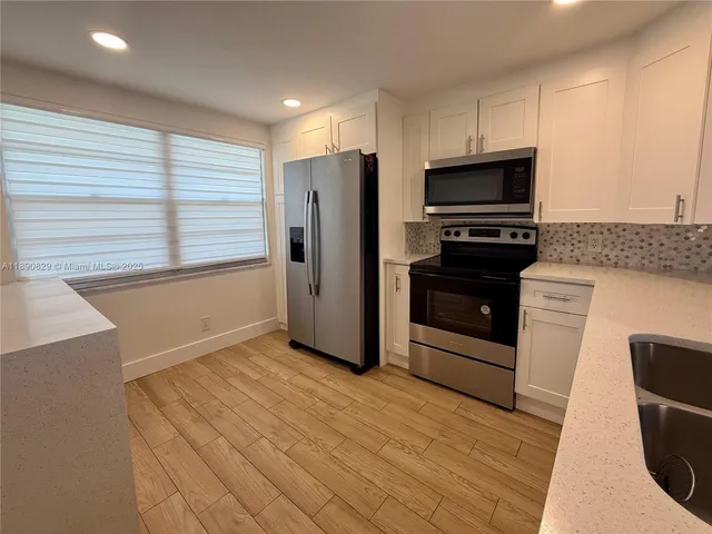 a kitchen with stainless steel appliances a refrigerator and a stove top oven