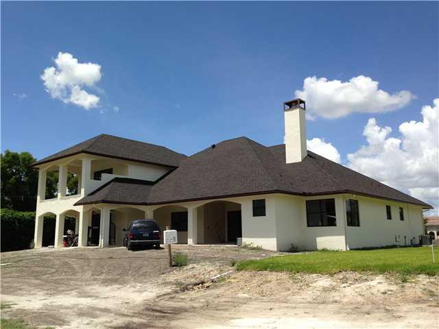 5050 Hancock Road Southwest Ranches, FL 33330 - Photo 2 of 13 a front view of a house with a yard and garage