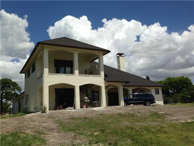 5050 Hancock Road Southwest Ranches, FL 33330 - Photo 3 of 13 a front view of a house with a yard and garage