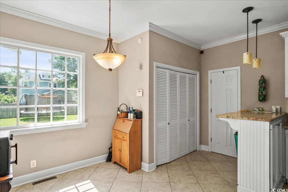 818 Evans Road Marion, SC 29571 - Photo 11 of 39 Kitchen with a breakfast bar, light tile patterned floors, ornamental molding, pendant lighting, and light stone counters