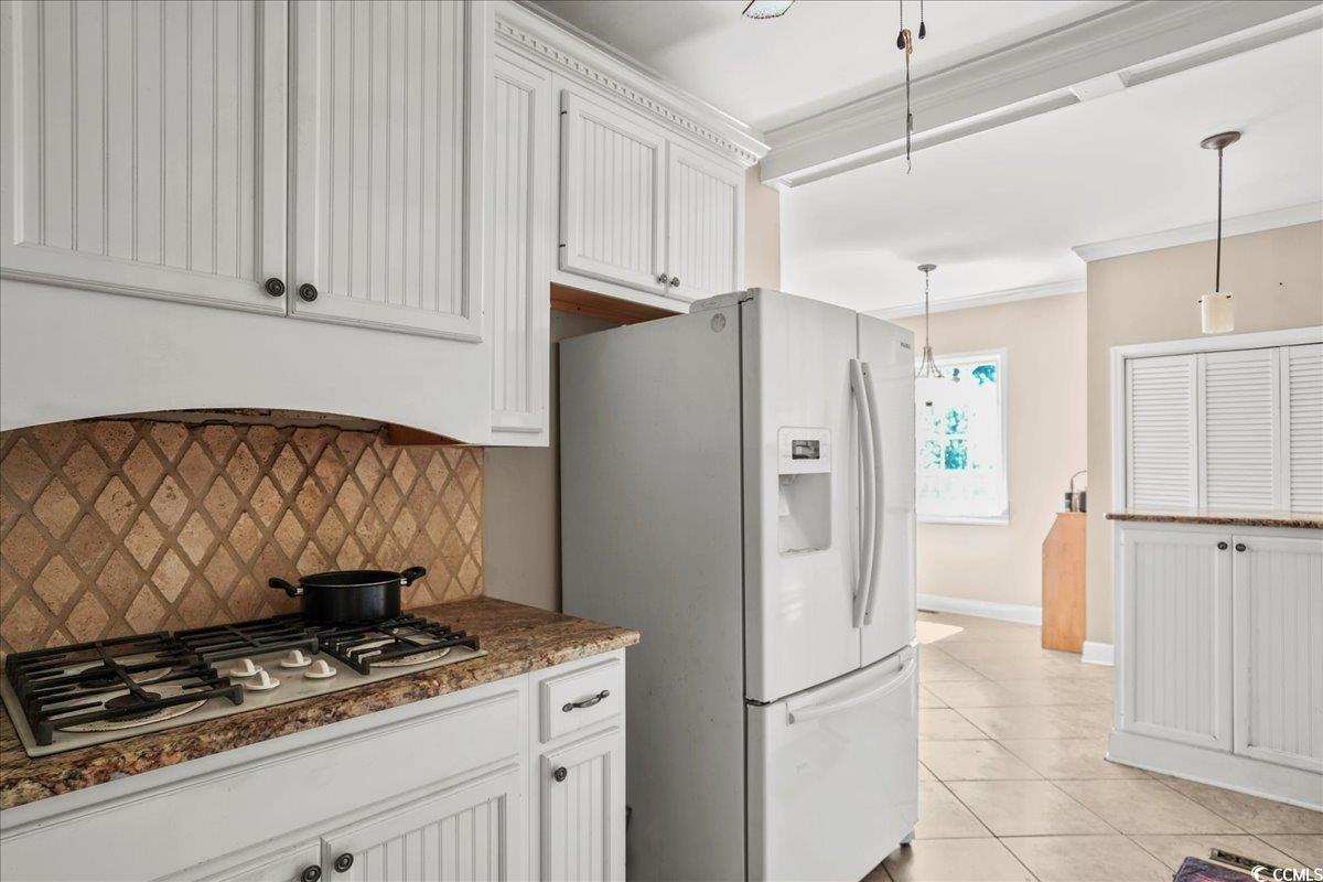 818 Evans Road Marion, SC 29571 - Photo 14 of 39 Kitchen featuring white appliances, backsplash, white cabinetry, light tile patterned floors, and ornamental molding