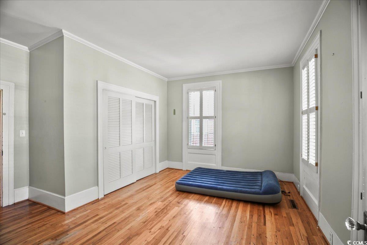 818 Evans Road Marion, SC 29571 - Photo 16 of 39 Bedroom featuring crown molding, wood finished floors, multiple windows, and a closet