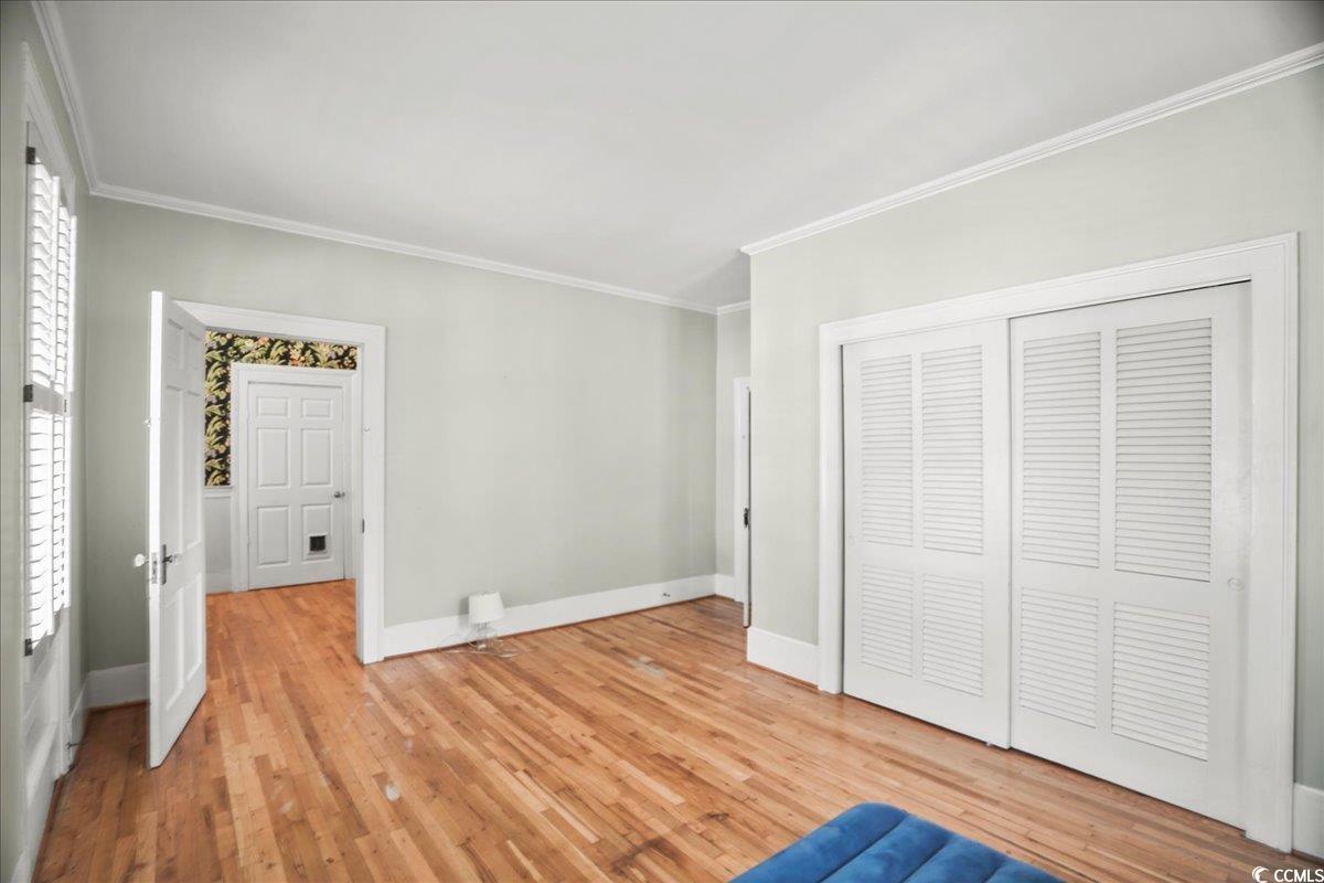 818 Evans Road Marion, SC 29571 - Photo 18 of 39 Unfurnished bedroom featuring crown molding, light wood-type flooring, and a closet