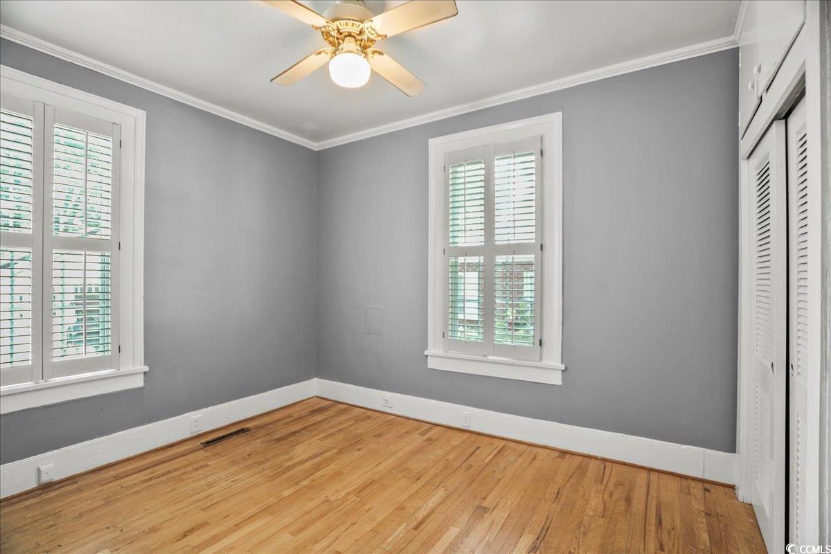 818 Evans Road Marion, SC 29571 - Photo 20 of 39 Unfurnished bedroom with crown molding, hardwood / wood-style floors, ceiling fan, and a closet