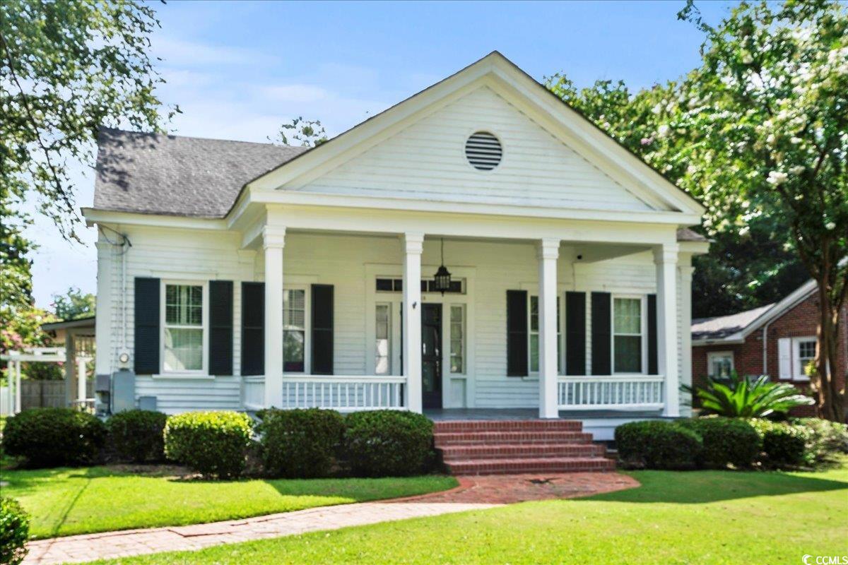 818 Evans Road Marion, SC 29571 - Photo 2 of 39 Greek revival inspired property featuring covered porch, a front yard, and roof with shingles