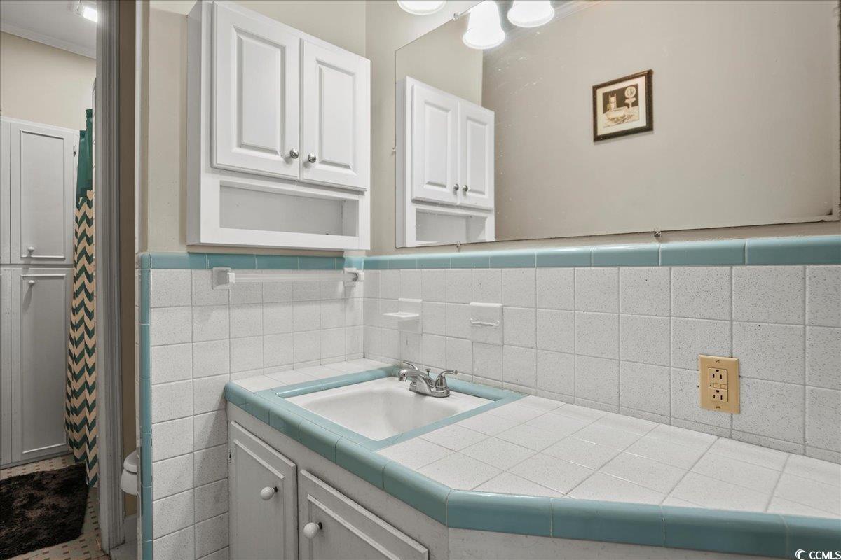 818 Evans Road Marion, SC 29571 - Photo 21 of 39 Bathroom featuring vanity, a shower with curtain, and tile walls