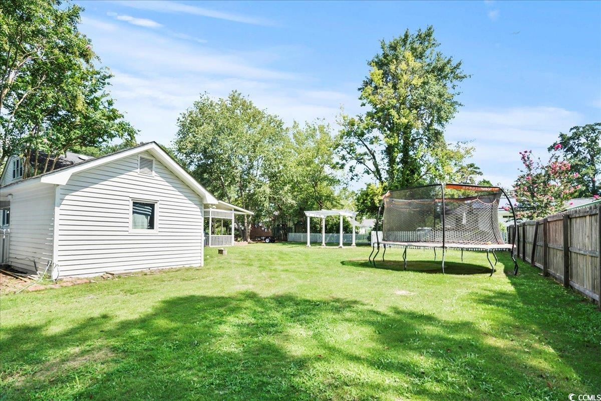 818 Evans Road Marion, SC 29571 - Photo 36 of 39 Fenced backyard featuring a trampoline and a sunroom