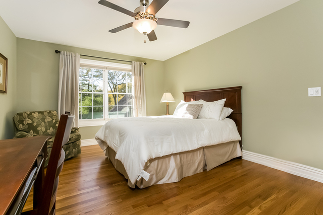 4553 Wolf Road Western Springs, IL 60558 - Photo 19 of 35 a spacious bedroom with a bed and wooden floor