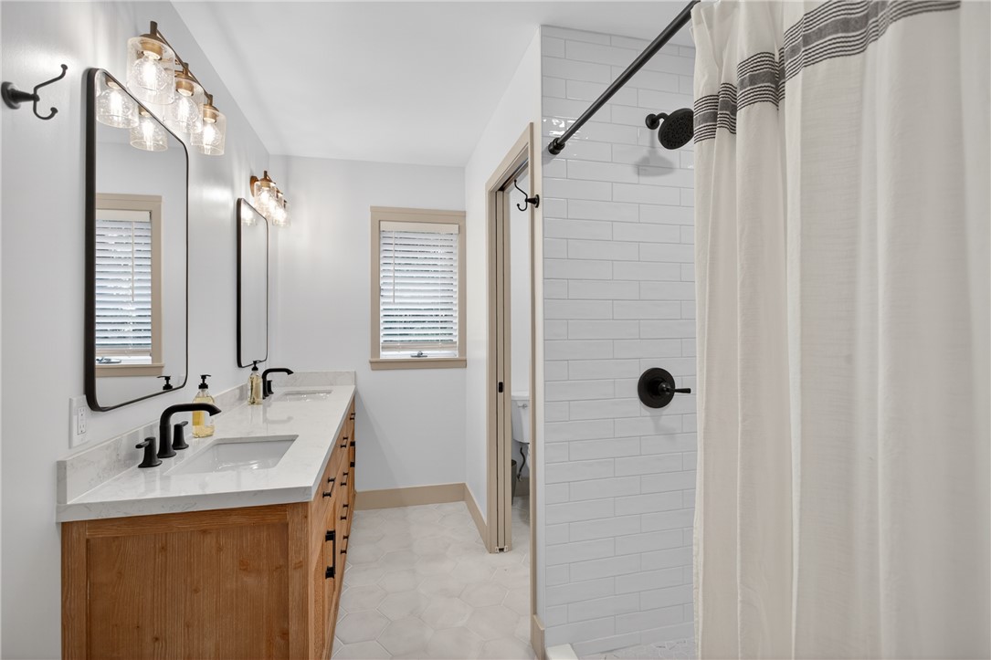304 Lakeside Drive Seneca, SC 29672 - Photo 24 of 50 Double vanity with sleek black fixtures and a spacious shower.