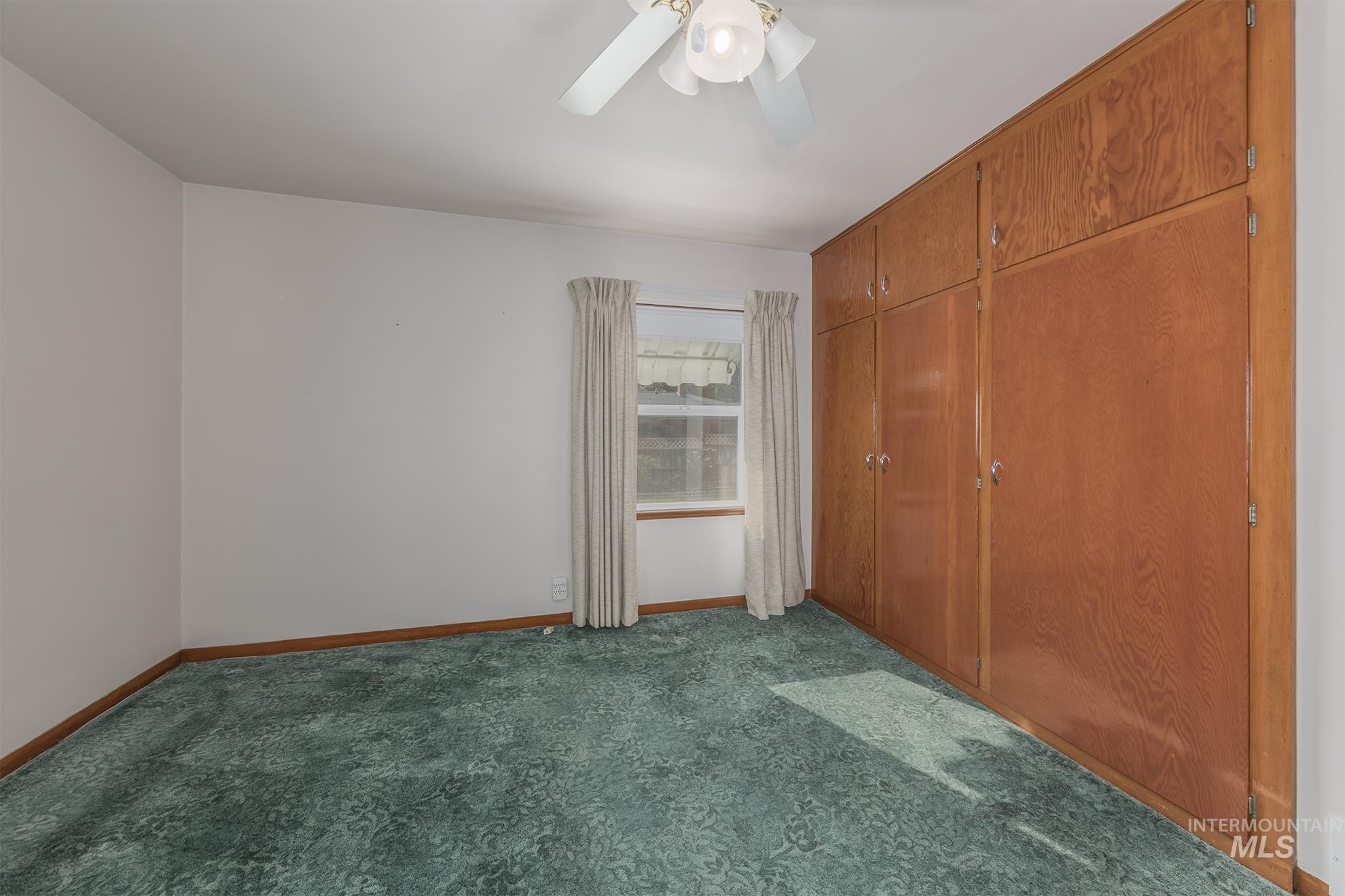 116 Pioneer Road Weiser, ID 83672 - Photo 13 of 41 Unfurnished bedroom with dark colored carpet, ceiling fan, and a closet