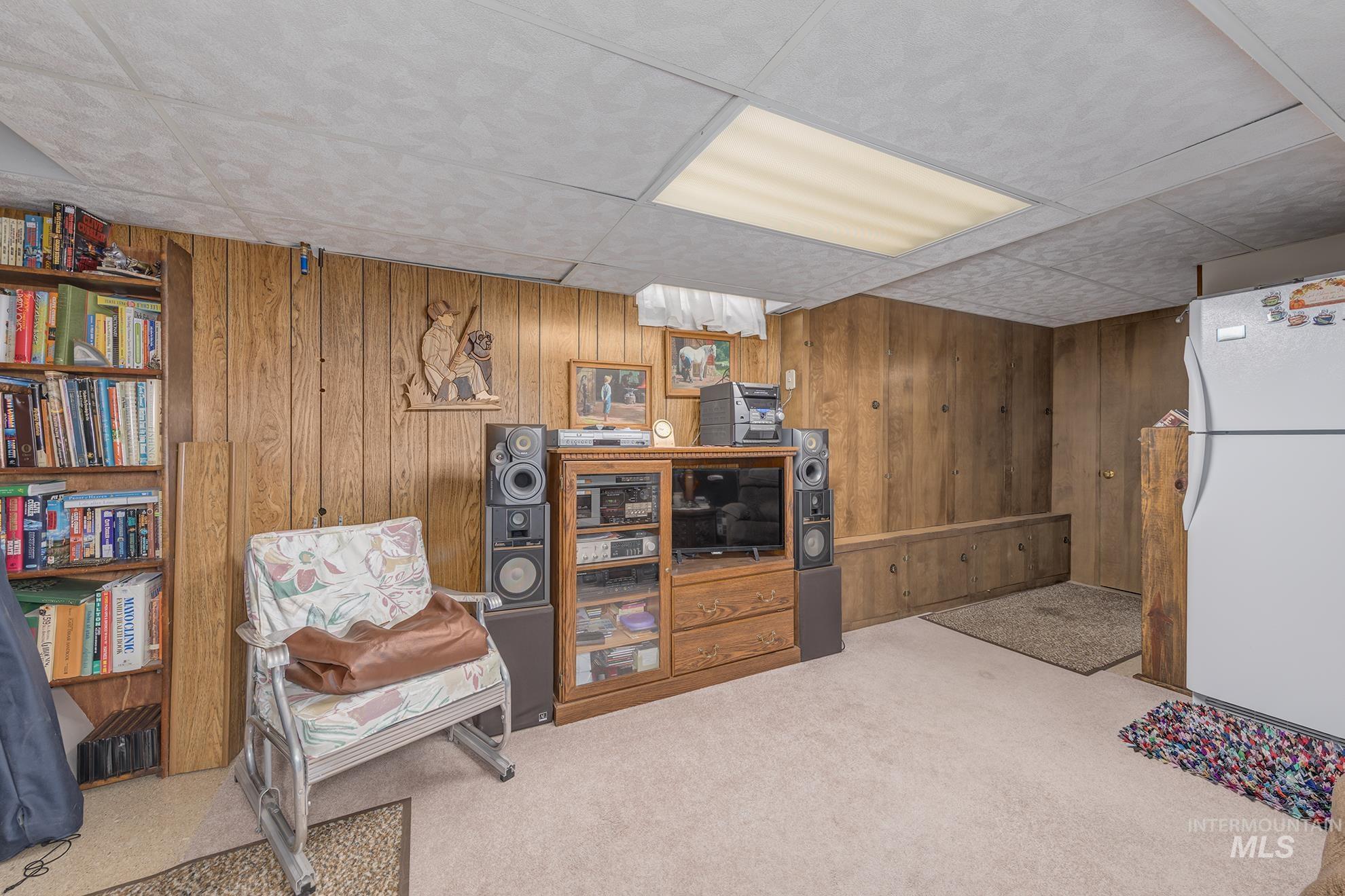 116 Pioneer Road Weiser, ID 83672 - Photo 20 of 41 Sitting room featuring a drop ceiling, wooden walls, and light colored carpet