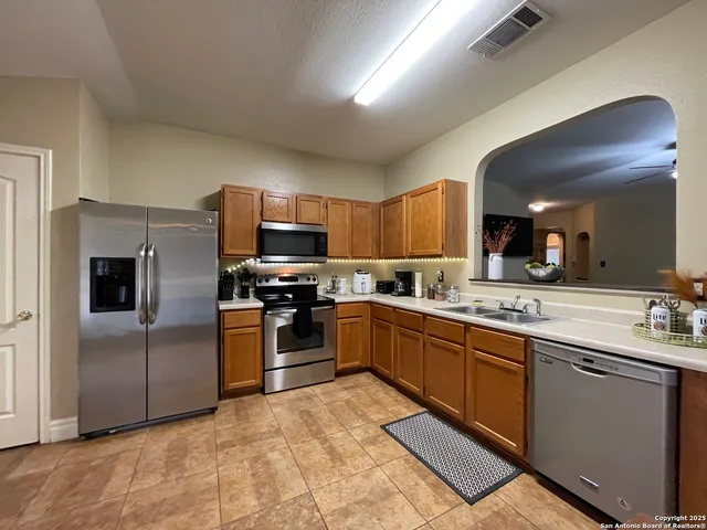 a kitchen with stainless steel appliances granite countertop a refrigerator a stove top oven a sink and dishwasher