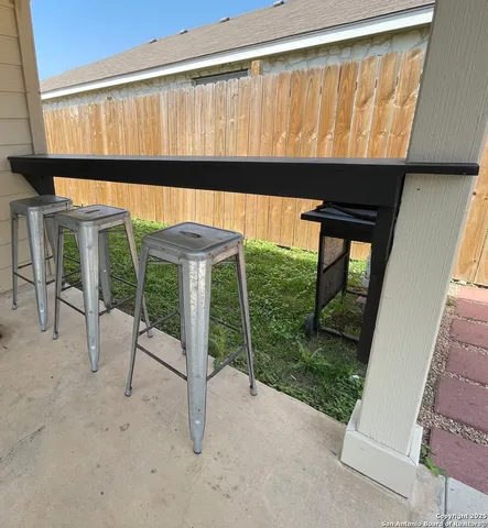 a porch with a table and chairs under an umbrella
