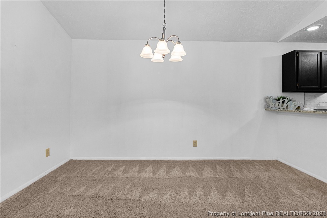 1899 Tryon Drive, Unit 8 Fayetteville, NC 28303 - Photo 10 of 25 a view of a room with a chandelier fan and kitchen view
