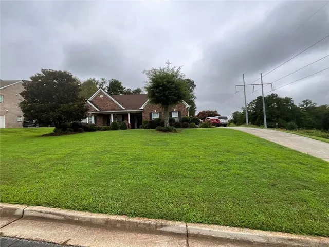 a front view of a house with yard and green space