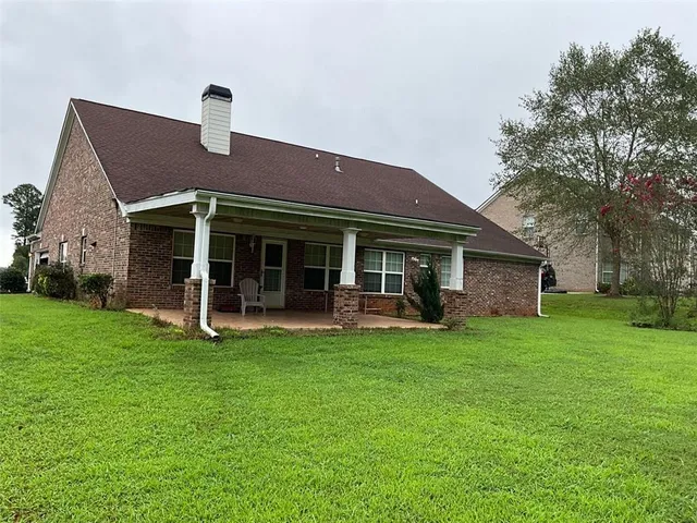 a view of a house with a yard and sitting area