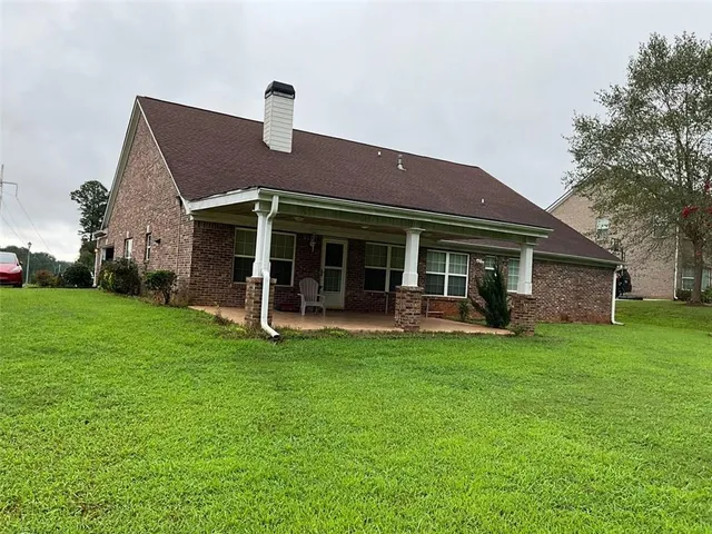 a view of a house with a yard deck and a small yard