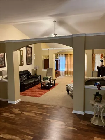 a view of a livingroom with furniture hardwood floor and a ceiling fan