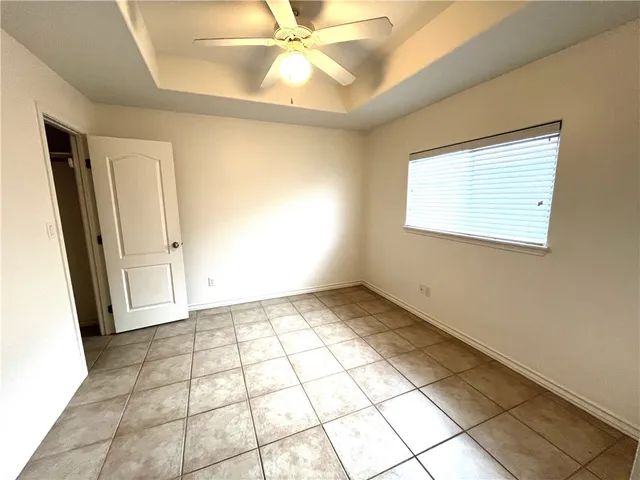 an empty room with windows and fan