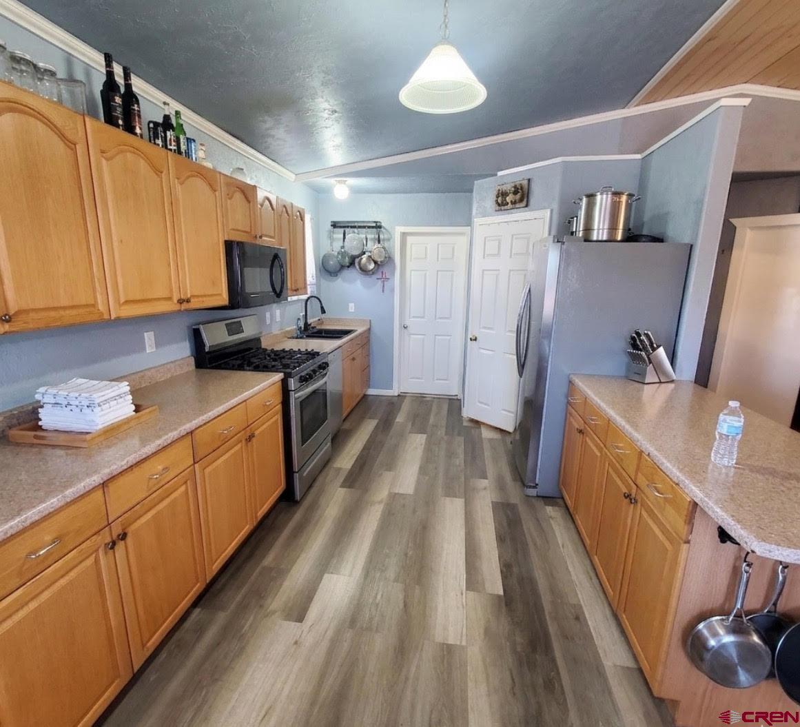 816 Main Street Manassa, CO 81141 - Photo 10 of 23 a kitchen with sink a microwave a refrigerator and cabinets