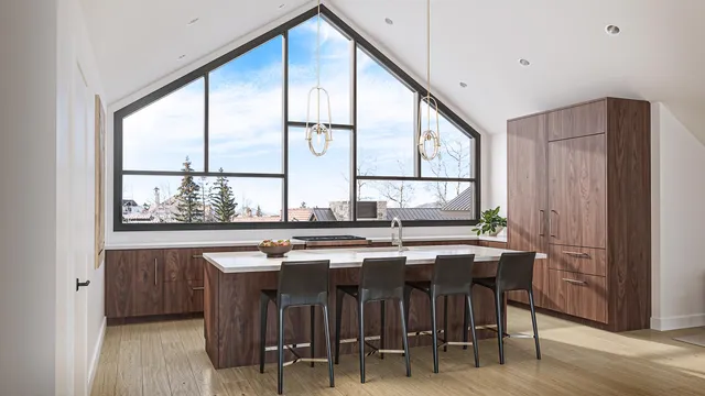 a kitchen with stainless steel appliances granite countertop a table chairs and a large window