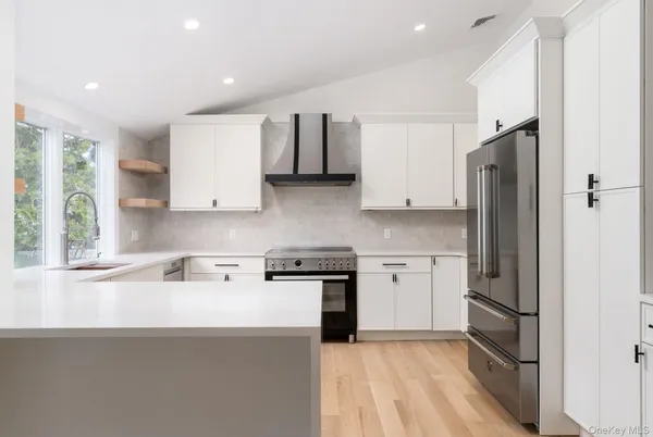 a kitchen with stainless steel appliances granite countertop a refrigerator sink and stove
