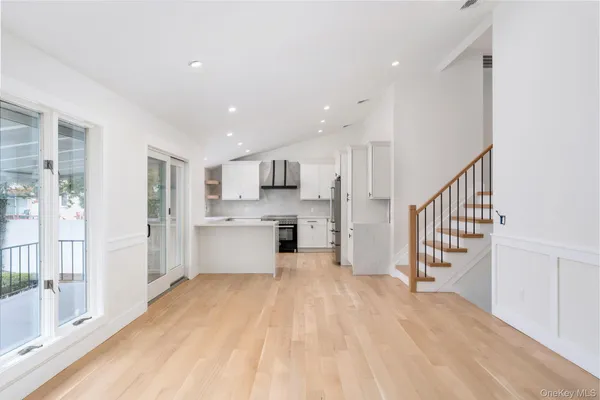 a view of a kitchen with wooden floor and electronic appliances