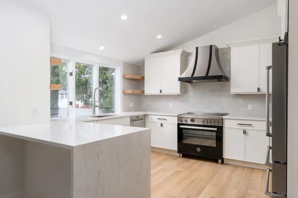 a kitchen with stainless steel appliances granite countertop a stove a sink and a refrigerator